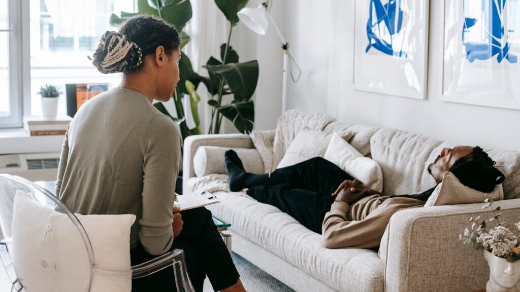 Ethnic man lying near psychologist
