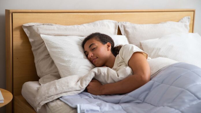 A woman sleeping in a mattress with a blanket