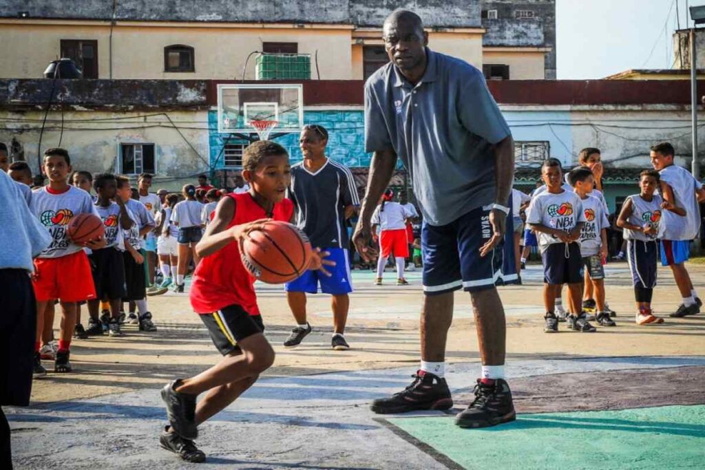 A picture of Dikembe Mutombo watching kids play