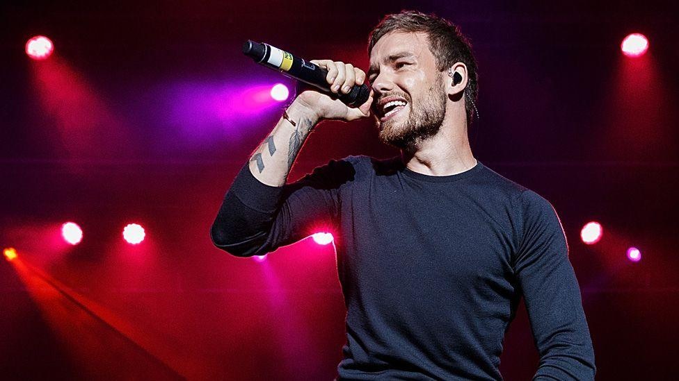 A picture of Liam Payne singing