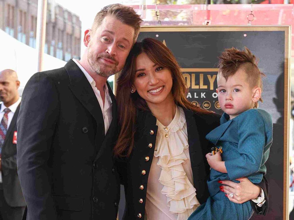 A picture of Macaulay Culkin and Brenda Song with child