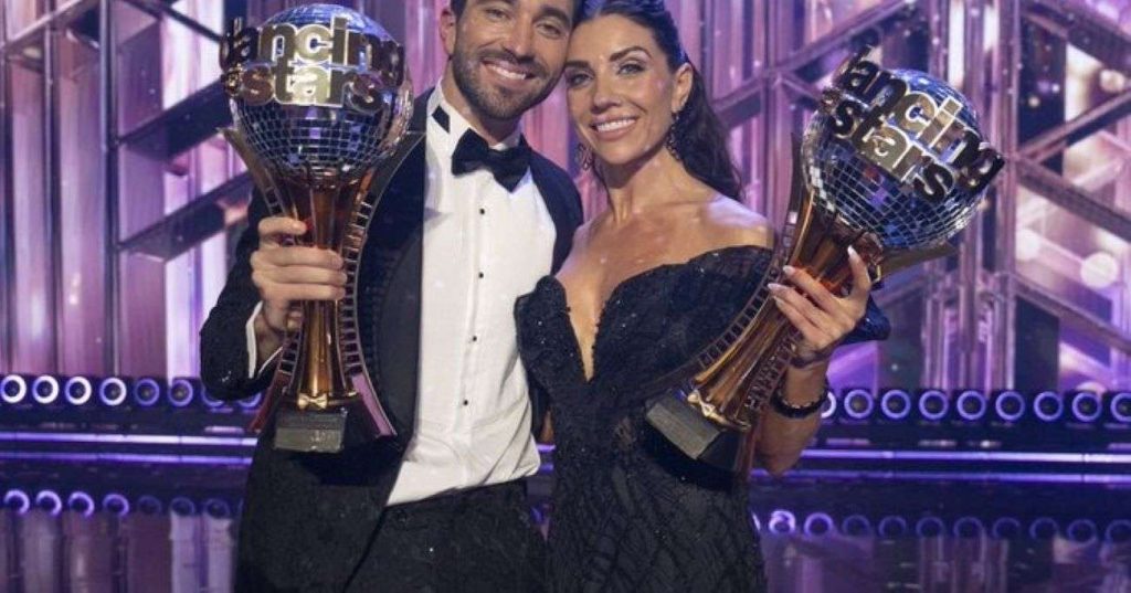 Joey Graziadei showing off his trophy alongside his DWTS partner